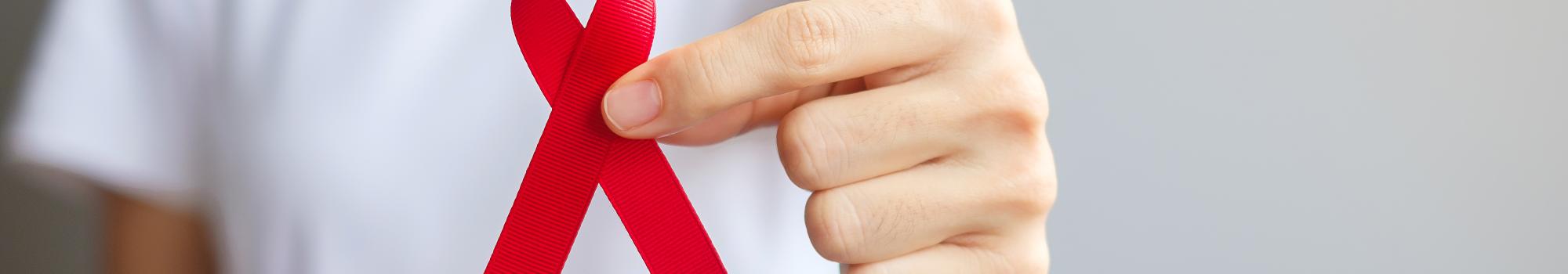 person holding up a red ribbon